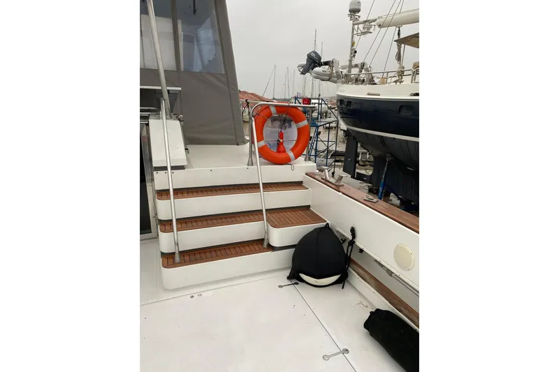 Captain Back Yacht Photos Pics Steps on a 1988 Cantiere Navale di Pesaro Studio Mare Atmosfere 46 yacht with lifebuoy.