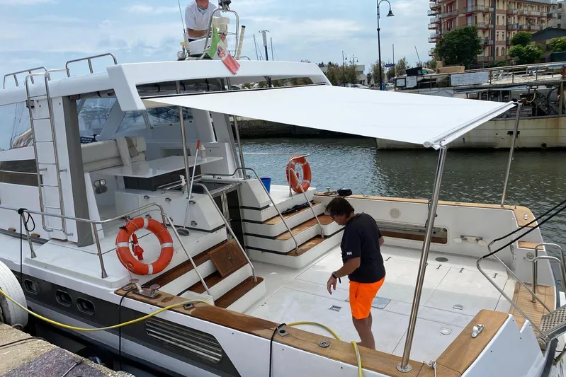 Captain Back Yacht Photos Pics 1988 Cantiere Navale di Pesaro Studio Mare Atmosfere 46 yacht docked, featuring spacious deck and canopy.