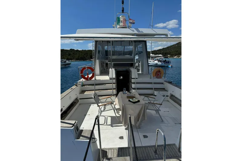 Captain Back Yacht Photos Pics Studio Mare Atmosfere 46 yacht, 1988 model, with outdoor dining setup on deck.