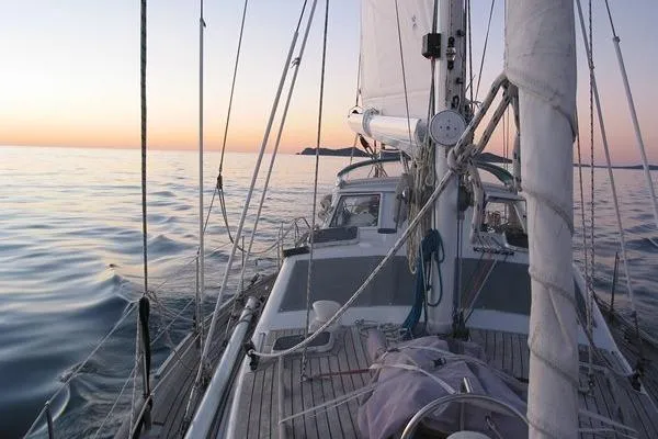 Raynad Yacht Photos Pics Sailing yacht "World Cruiser" on calm sea at sunset, Custom Steel Cutter, 2000 model.