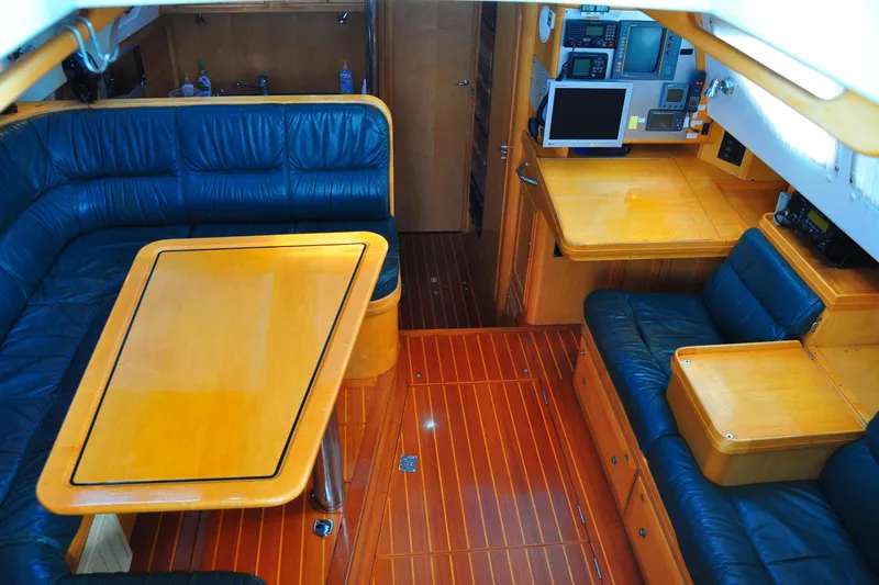 Raynad Yacht Photos Pics Luxurious interior of 2000 Custom Steel Cutter World Cruiser yacht with leather seating and wooden finishes.