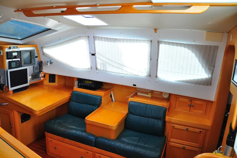 Raynad Yacht Photos Pics Interior of 2000 Custom Steel Cutter World Cruiser with navigation equipment and seating area.