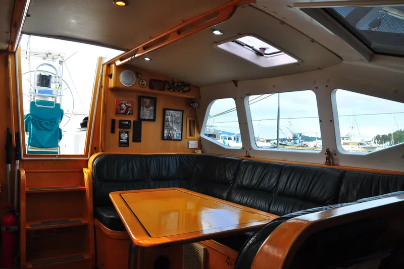 Raynad Yacht Photos Pics Interior of 2000 Custom Steel Cutter World Cruiser with leather seating and wooden table.