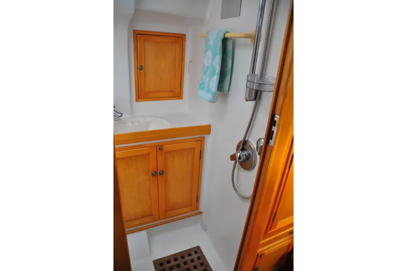 Raynad Yacht Photos Pics Compact bathroom in 2000 Custom Steel Cutter World Cruiser yacht with wooden cabinets.
