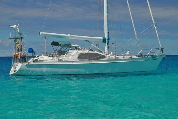 Raynad Yacht Photos Pics Custom Steel Cutter World Cruiser 2000 sailboat on clear turquoise water.