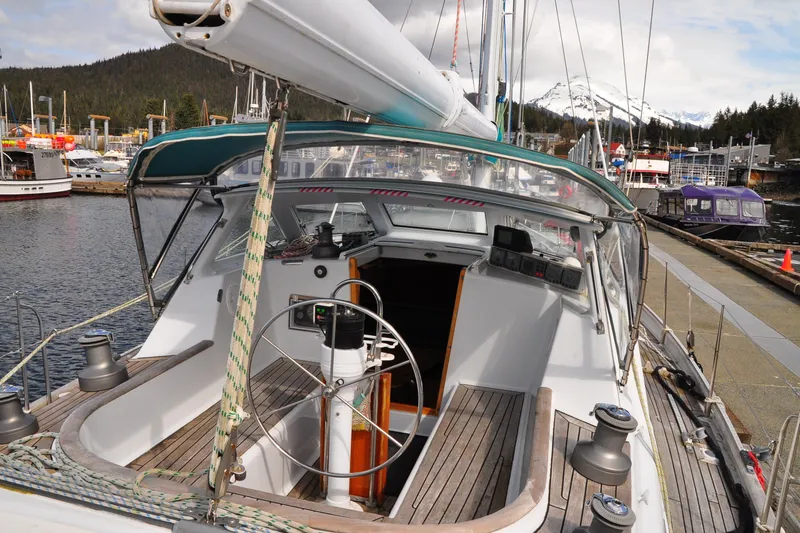 Raynad Yacht Photos Pics Sailboat docked at marina, Custom Steel Cutter World Cruiser, 2000 model, scenic mountain backdrop.