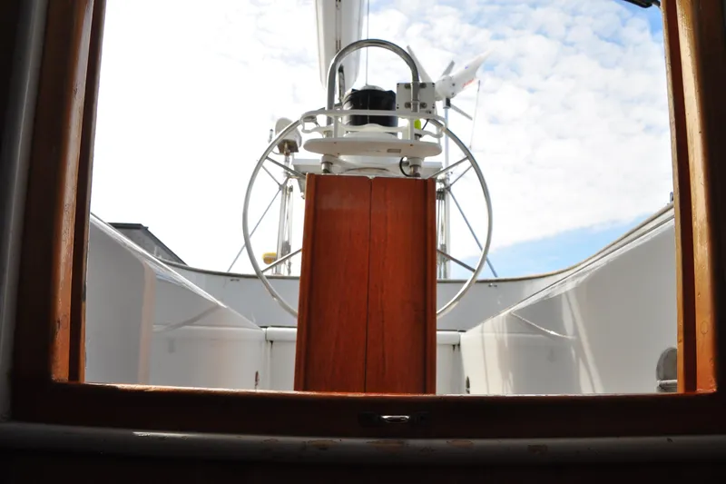 Raynad Yacht Photos Pics Cockpit view of 2000 Custom Steel Cutter World Cruiser sailboat under a partly cloudy sky.