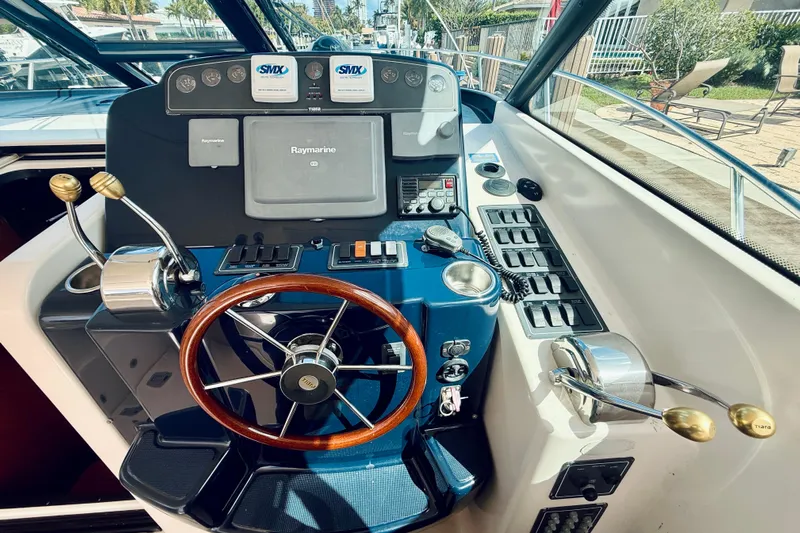 Lola Yacht Photos Pics 2005 Tiara Yachts 3600 Sovran helm with Raymarine navigation and wooden steering wheel.