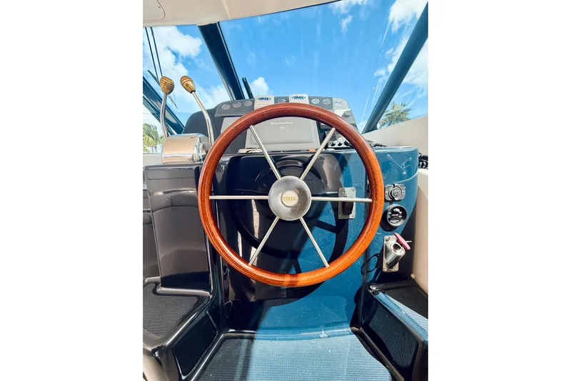 Lola Yacht Photos Pics 2005 Tiara Yachts 3600 Sovran helm with wooden steering wheel and navigation controls.