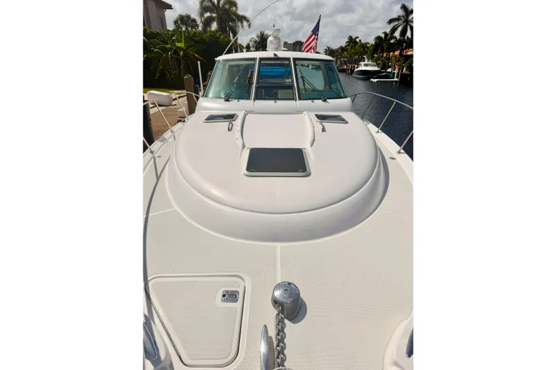 Lola Yacht Photos Pics 2005 Tiara Yachts 3600 Sovran boat deck with American flag, docked in a canal.