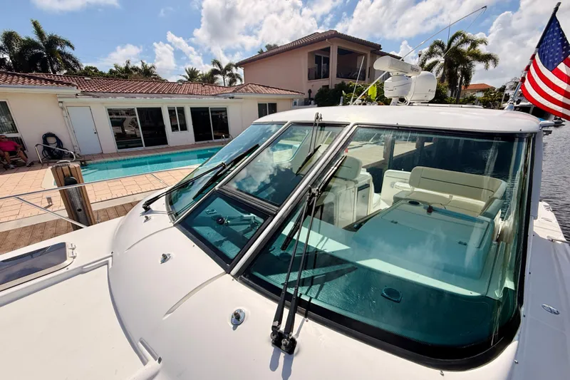 Lola Yacht Photos Pics 2005 Tiara Yachts 3600 Sovran docked by a poolside home with American flag.