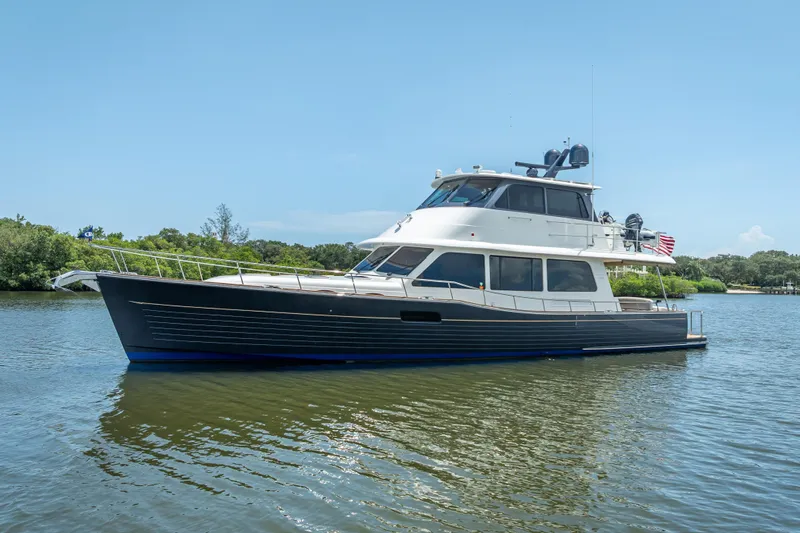 Escape Yacht Photos Pics 2022 Grand Banks GB60 yacht on calm water, showcasing sleek design and luxury features.