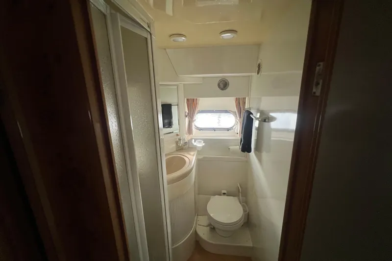  Yacht Photos Pics Compact bathroom in a 2001 Jefferson International 5300, featuring a shower, sink, and toilet.