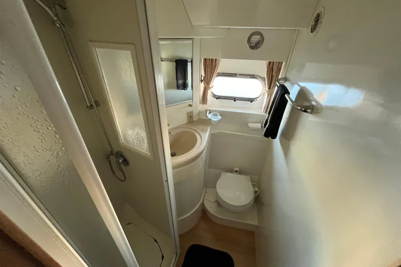  Yacht Photos Pics Compact bathroom in a 2001 Jefferson International 5300, featuring shower, sink, and toilet.