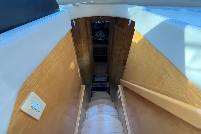  Yacht Photos Pics Staircase inside 2001 Jefferson International 5300 yacht, featuring wooden paneling and a light switch.