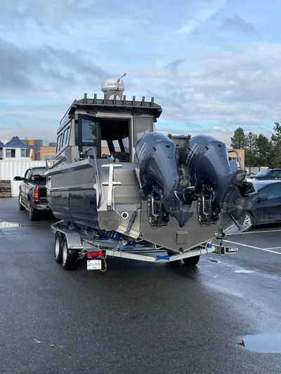  Yacht Photos Pics Custom 2022 aluminum fishing boat with dual outboard motors on a trailer in a parking lot.