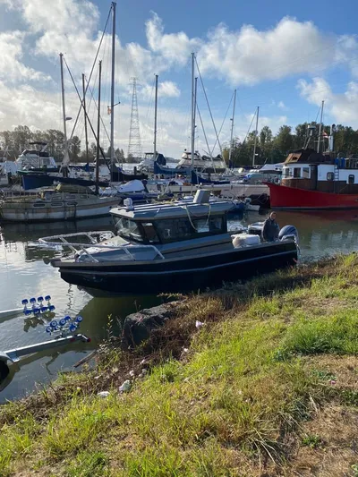  Yacht Photos Pics 2022 Custom Aluminum Fishing boat docked in a marina with sailboats in the background.