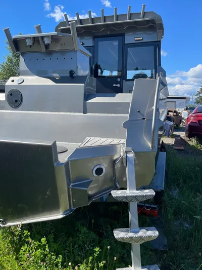  Yacht Photos Pics Custom 2022 aluminum fishing boat with sturdy design, docked outdoors under a clear blue sky.