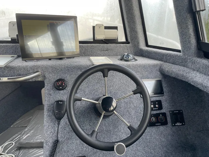  Yacht Photos Pics 2022 Custom Aluminum Fishing boat cockpit with steering wheel, navigation screen, and control panel.