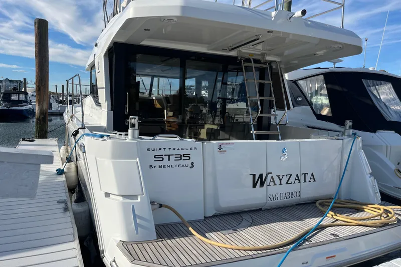  Yacht Photos Pics 2019 Beneteau Swift Trawler 35 docked at marina, rear view with open deck.