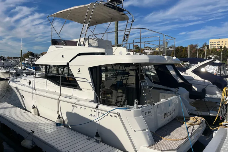  Yacht Photos Pics 2019 Beneteau Swift Trawler 35 docked at marina under clear blue sky.