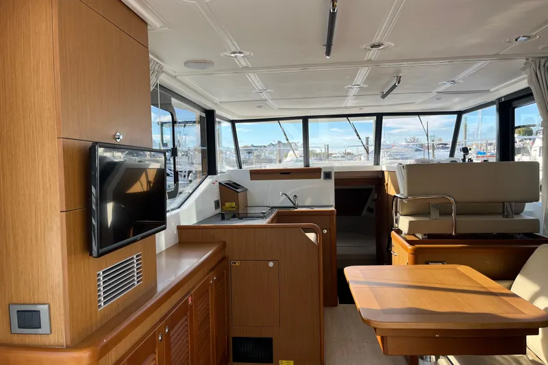  Yacht Photos Pics Interior of 2019 Beneteau Swift Trawler 35 with modern wood finish and large windows.