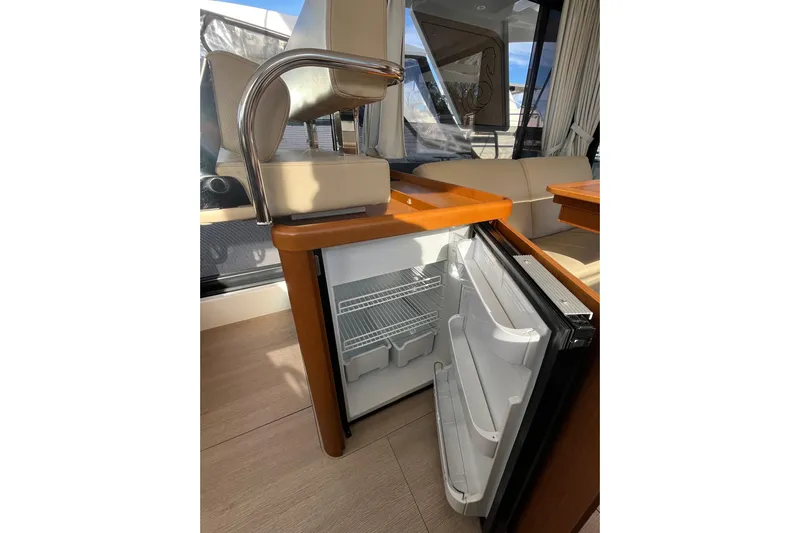  Yacht Photos Pics Interior of 2019 Beneteau Swift Trawler 35 with open mini fridge and seating area.