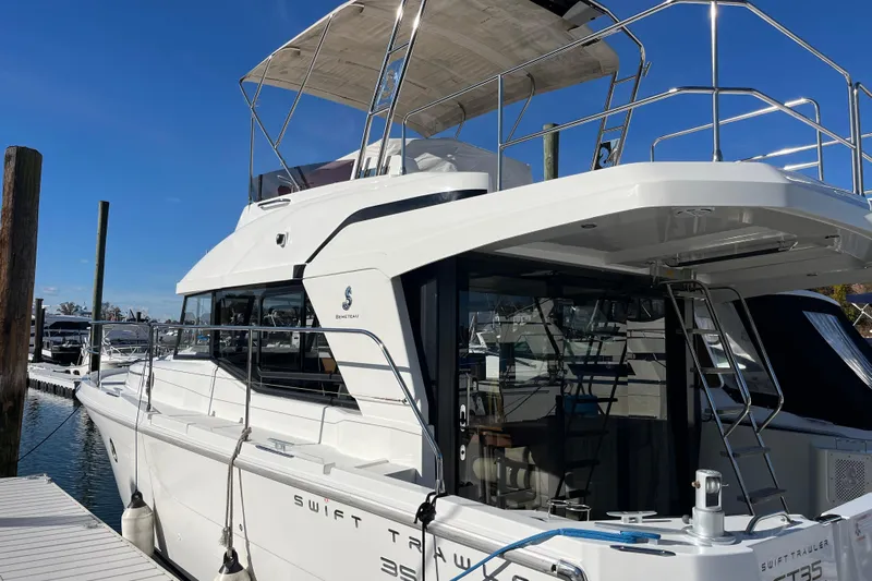  Yacht Photos Pics 2019 Beneteau Swift Trawler 35 docked at marina, showcasing sleek design and spacious deck.