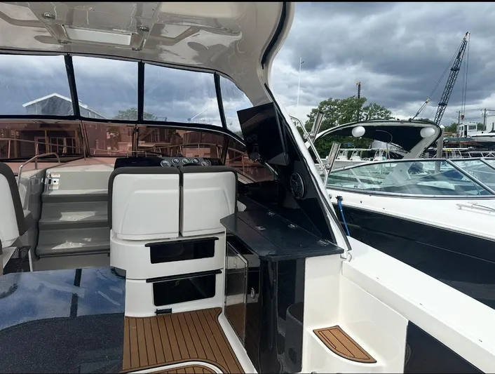 Pocket Change Yacht Photos Pics 2016 Sea Ray 370 Sundancer interior with helm, seating, and wooden deck, docked at marina.