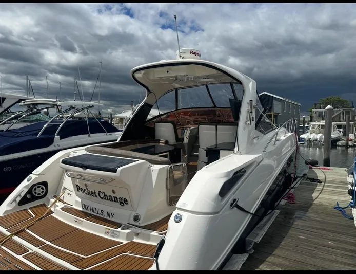 Pocket Change Yacht Photos Pics 2016 Sea Ray 370 Sundancer docked, featuring sleek design and spacious deck under cloudy skies.