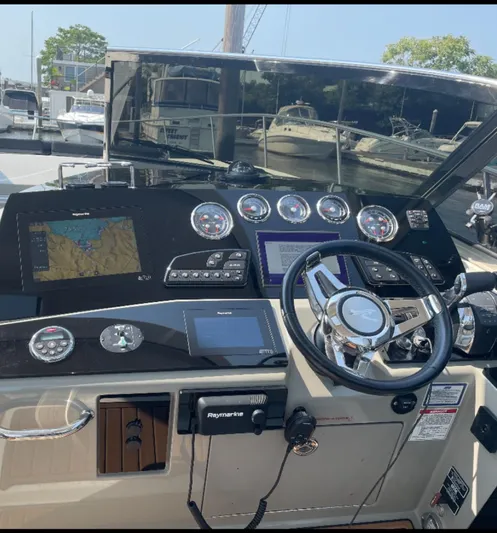 Pocket Change Yacht Photos Pics Helm of 2016 Sea Ray 370 Sundancer with navigation equipment and steering wheel.