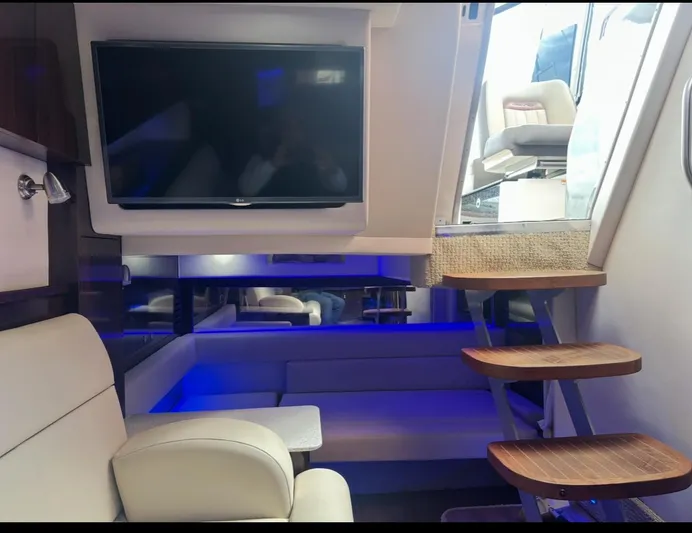 Pocket Change Yacht Photos Pics Interior of 2016 Sea Ray 370 Sundancer with TV, seating, and wooden steps.