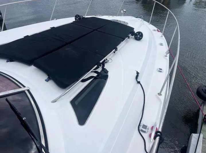 Pocket Change Yacht Photos Pics 2016 Sea Ray 370 Sundancer yacht deck with black sun pads and railing.