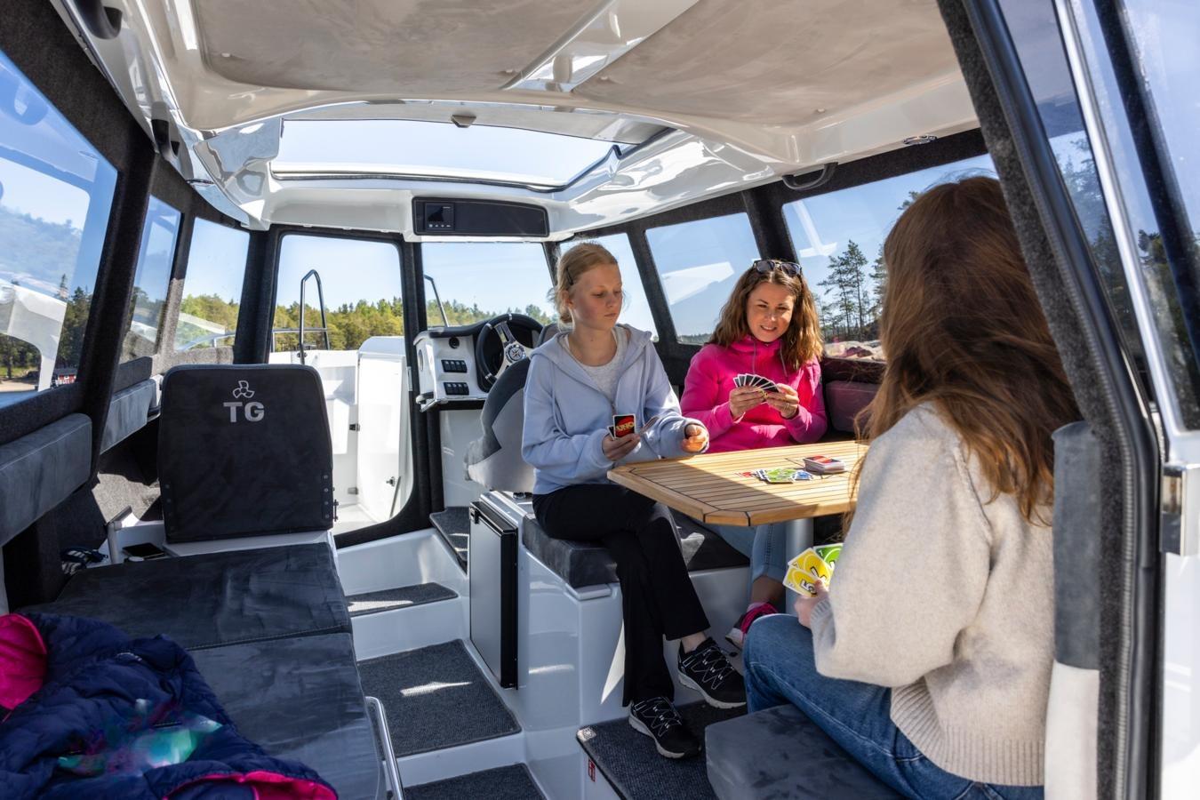 Interior of 2025 TG 7.9 Supreme boat with people playing cards at a table.