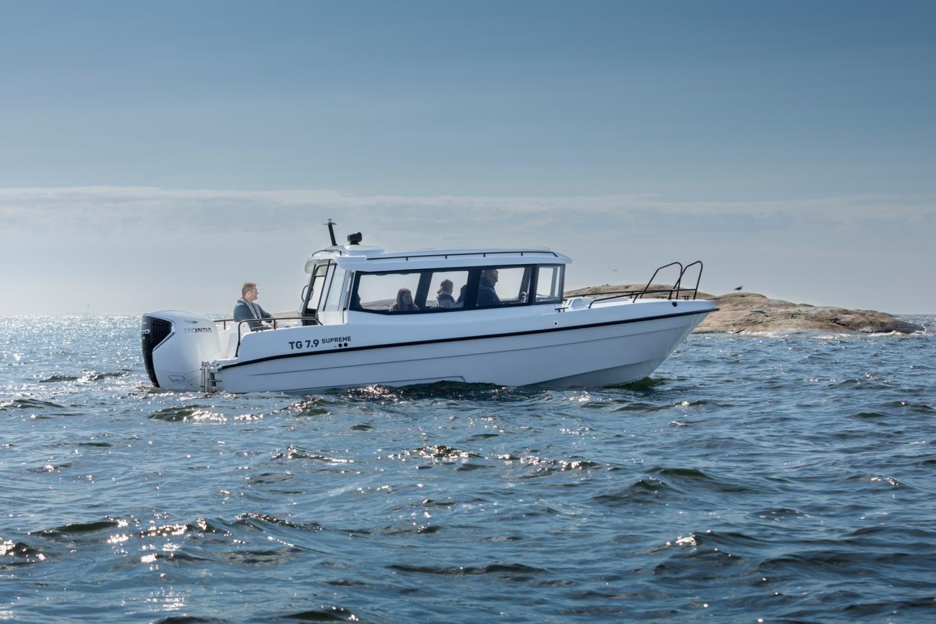 2025 TG 7.9 Supreme boat cruising on open water near rocky shoreline.