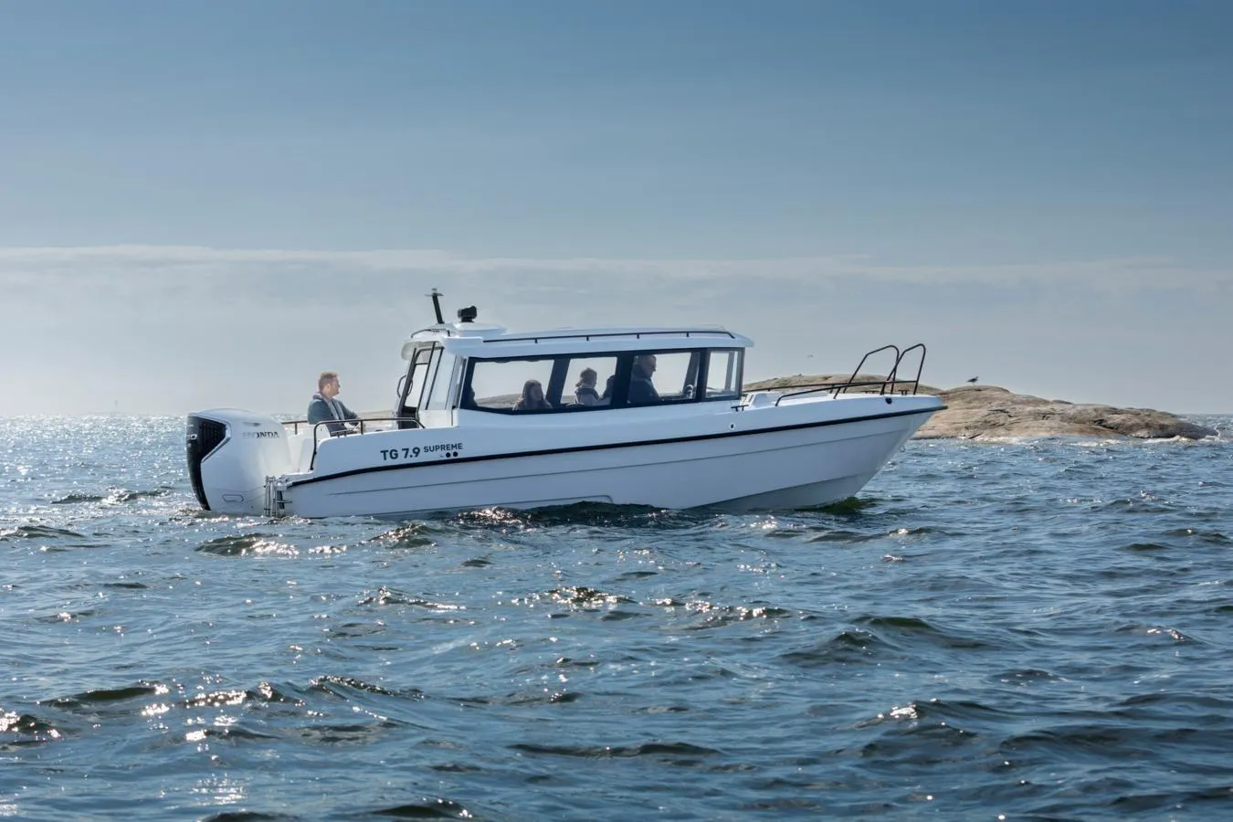 2025 TG 7.9 Supreme boat cruising on open water near rocky shoreline.
