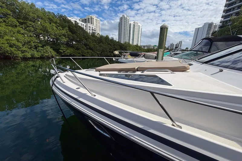 Sophia Yacht Photos Pics 2015 Regal 38 Express yacht docked near lush greenery and urban skyline.