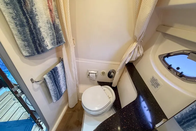 Sophia Yacht Photos Pics Bathroom interior of 2015 Regal 38 Express yacht with toilet, window, and towels.