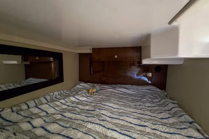 Sophia Yacht Photos Pics 2015 Regal 38 Express cabin interior with bed, mirror, and wooden cabinet.