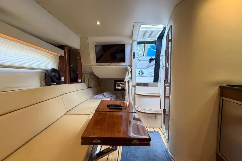 Sophia Yacht Photos Pics Luxurious interior of 2015 Regal 38 Express yacht with beige seating and wooden table.