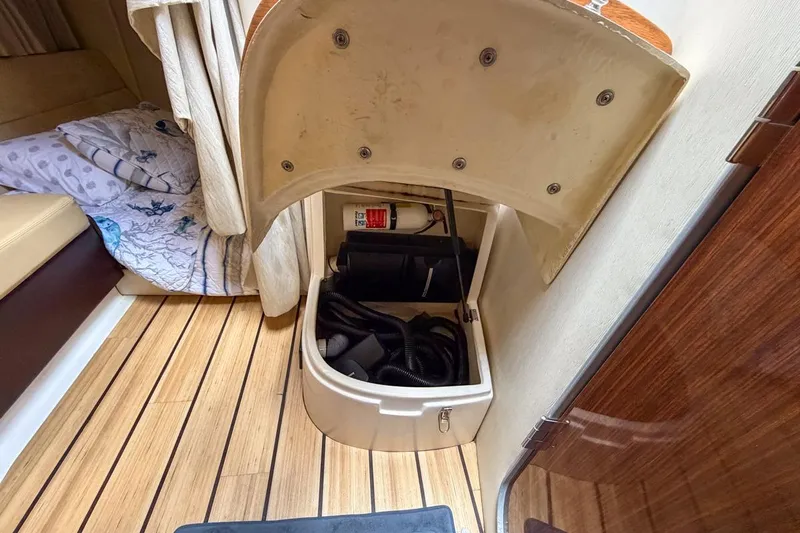Sophia Yacht Photos Pics 2015 Regal 38 Express interior storage compartment with wooden flooring and cozy bedding.