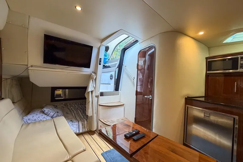 Sophia Yacht Photos Pics Interior of 2015 Regal 38 Express yacht with cozy seating, TV, and kitchenette.