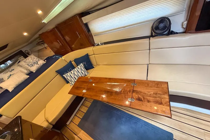 Sophia Yacht Photos Pics Luxurious interior of 2015 Regal 38 Express yacht with beige seating and wooden table.