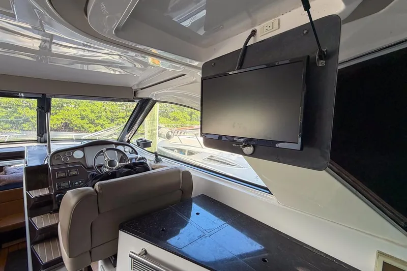 Sophia Yacht Photos Pics Interior of 2015 Regal 38 Express yacht with steering wheel and mounted TV.