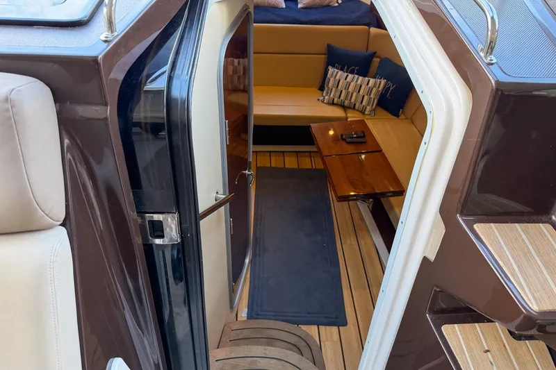 Sophia Yacht Photos Pics Interior view of 2015 Regal 38 Express yacht with cozy seating and wooden table.