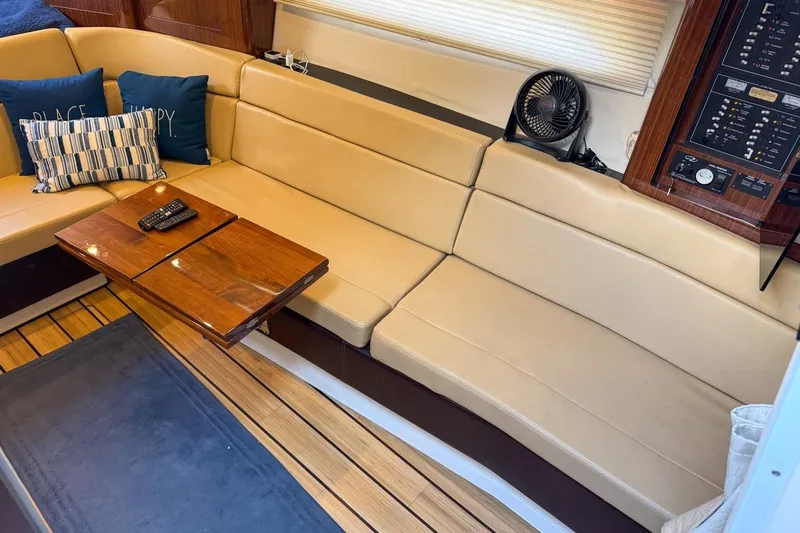 Sophia Yacht Photos Pics Luxurious interior of 2015 Regal 38 Express yacht with beige seating and wooden table.