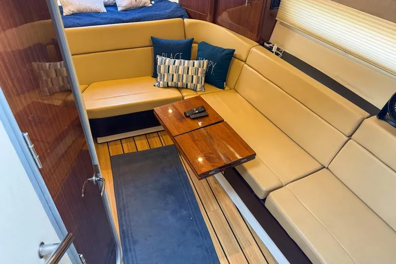 Sophia Yacht Photos Pics Luxurious interior of 2015 Regal 38 Express yacht with beige seating and wooden table.