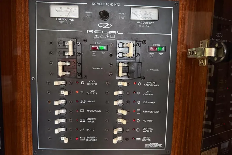 Sophia Yacht Photos Pics Electrical control panel of a 2015 Regal 38 Express boat, featuring various switches and indicators.