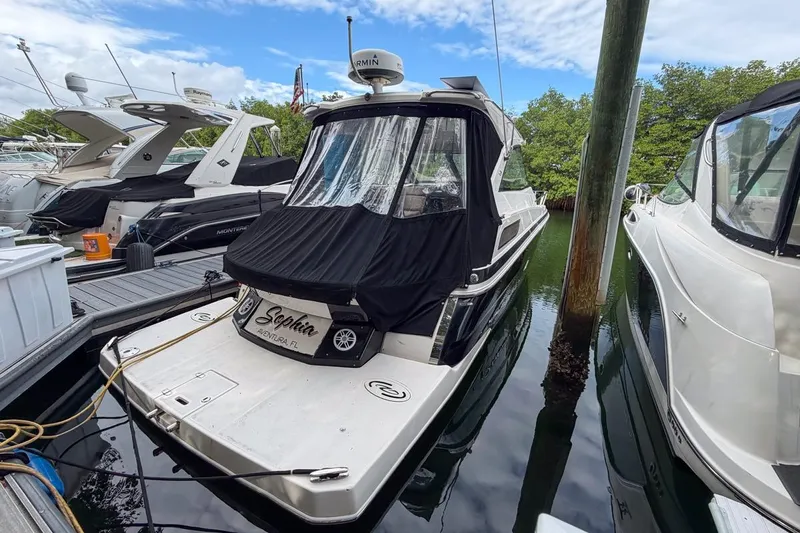 Sophia Yacht Photos Pics 2015 Regal 38 Express yacht docked, covered in black canvas, surrounded by other boats.