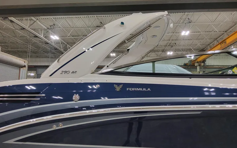  Yacht Photos Pics 2026 Formula 290 Bowrider boat in a showroom, featuring sleek blue and white design.